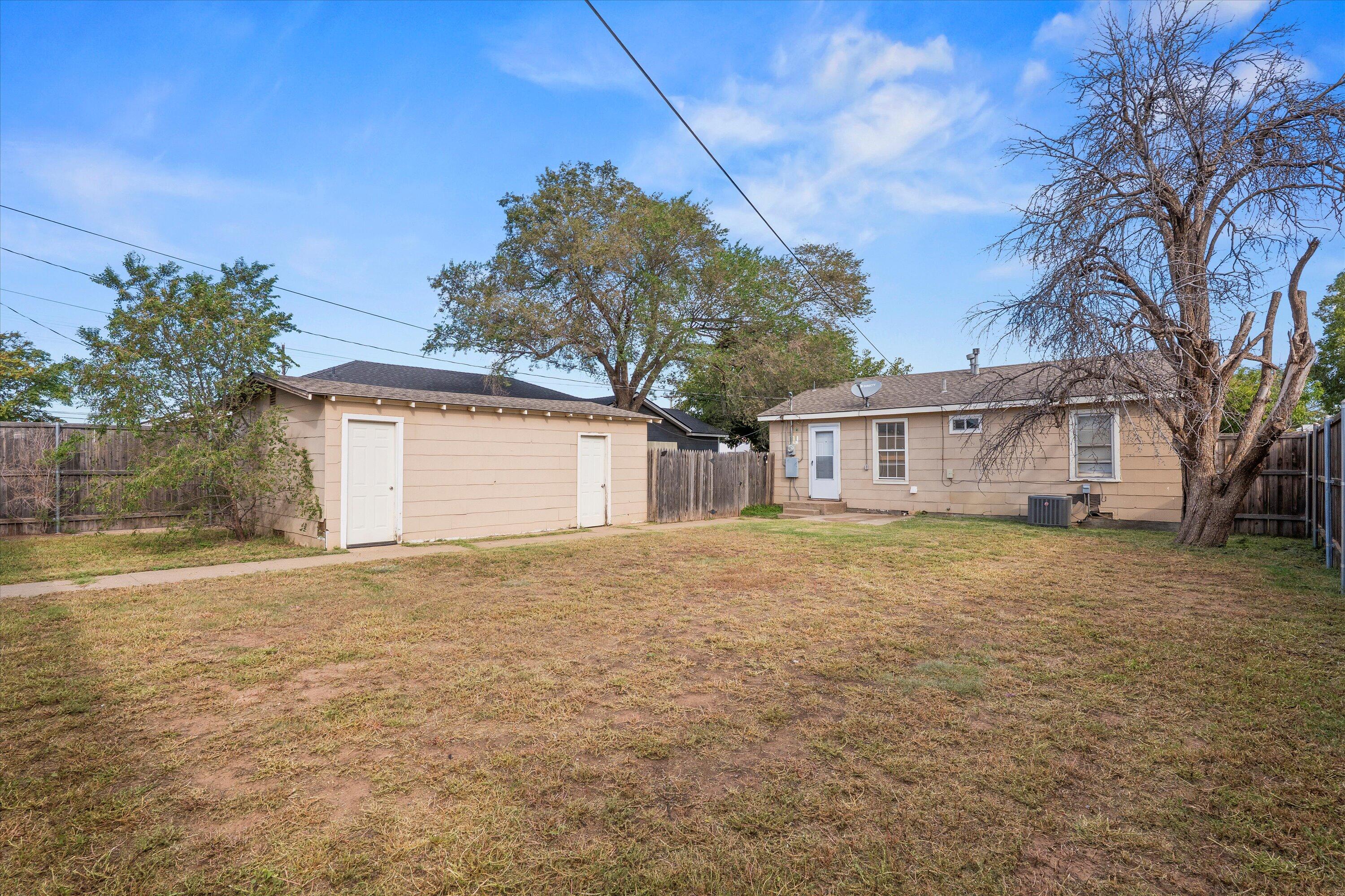 4315 33rd Street Lubbock, TX 79410 - Photo 14 of 16 a front view of a house with a garden and trees