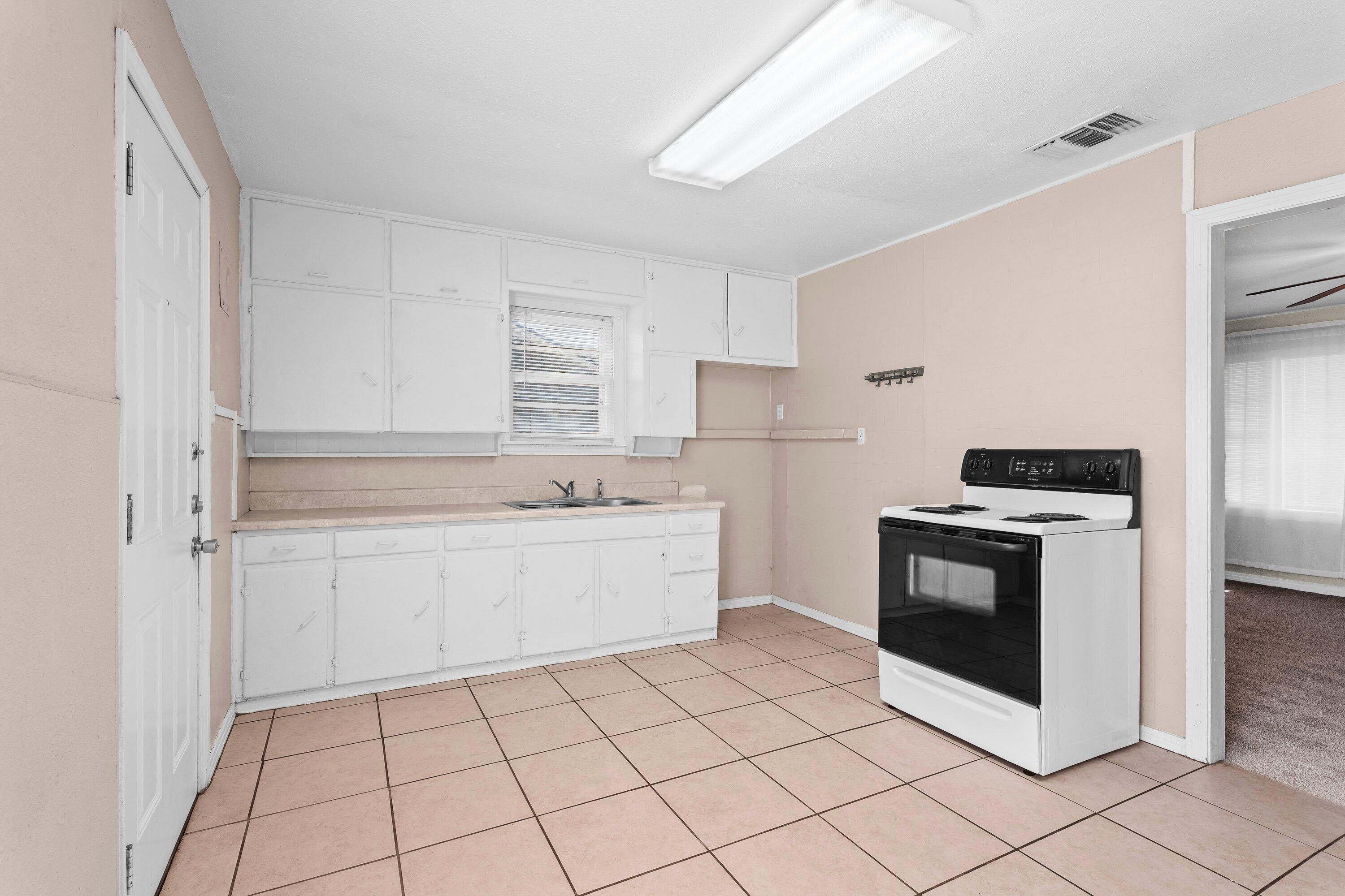 4315 33rd Street Lubbock, TX 79410 - Photo 6 of 16 a kitchen with granite countertop white cabinets and white appliances