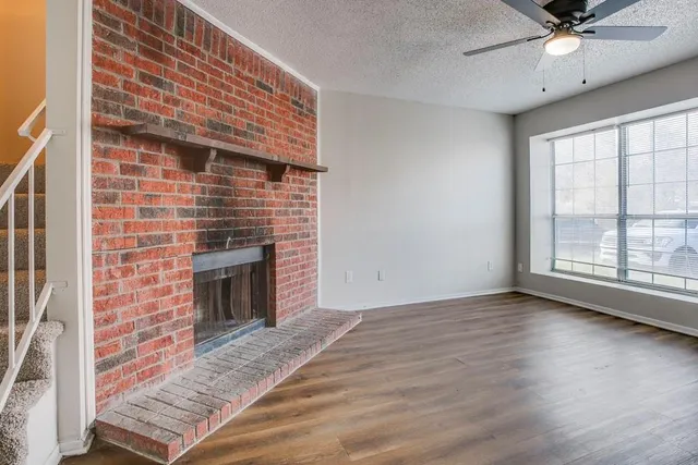 a view of an empty room with a fireplace and a window