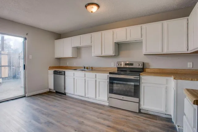 a kitchen with granite countertop a stove a sink and a refrigerator
