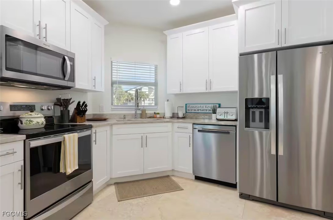 2740 North Beach Road, Unit A & B Englewood, FL 34223 - Photo 15 of 43 a kitchen with stainless steel appliances granite countertop a refrigerator stove a sink and a microwave