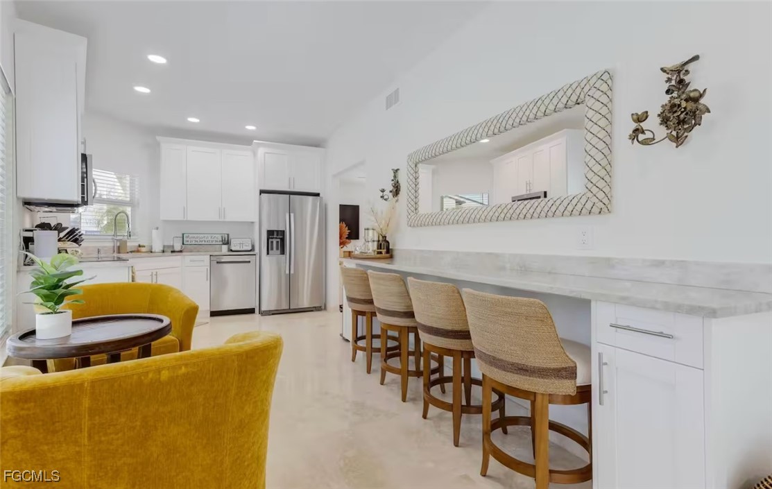 2740 North Beach Road, Unit A & B Englewood, FL 34223 - Photo 37 of 43 a kitchen with stainless steel appliances granite countertop a table chairs refrigerator and sink