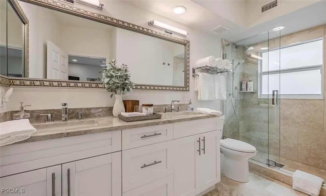 2740 North Beach Road, Unit A & B Englewood, FL 34223 - Photo 41 of 43 a bathroom with a granite countertop sink a toilet and a mirror