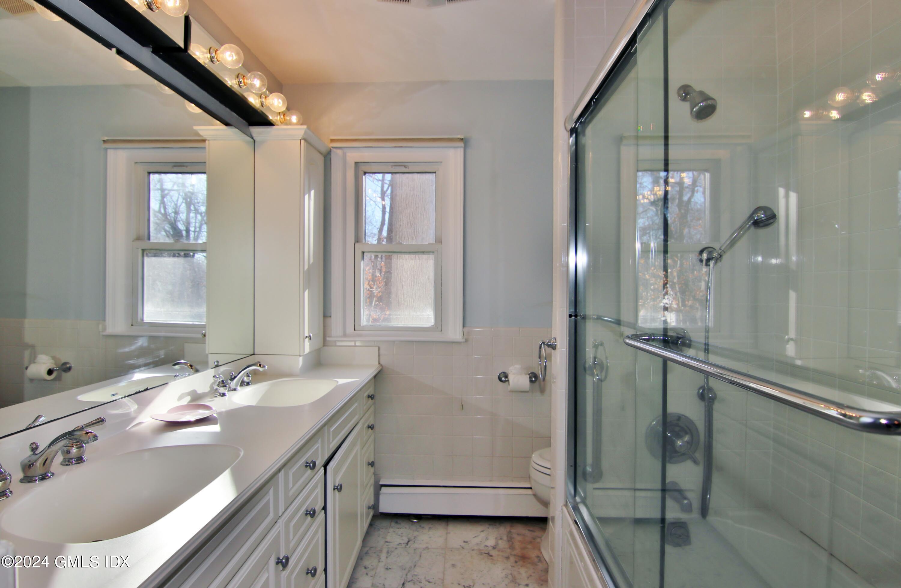 191 Sawmill Road Stamford, CT 06903 - Photo 22 of 40 a bathroom with a double vanity sink a mirror and a shower