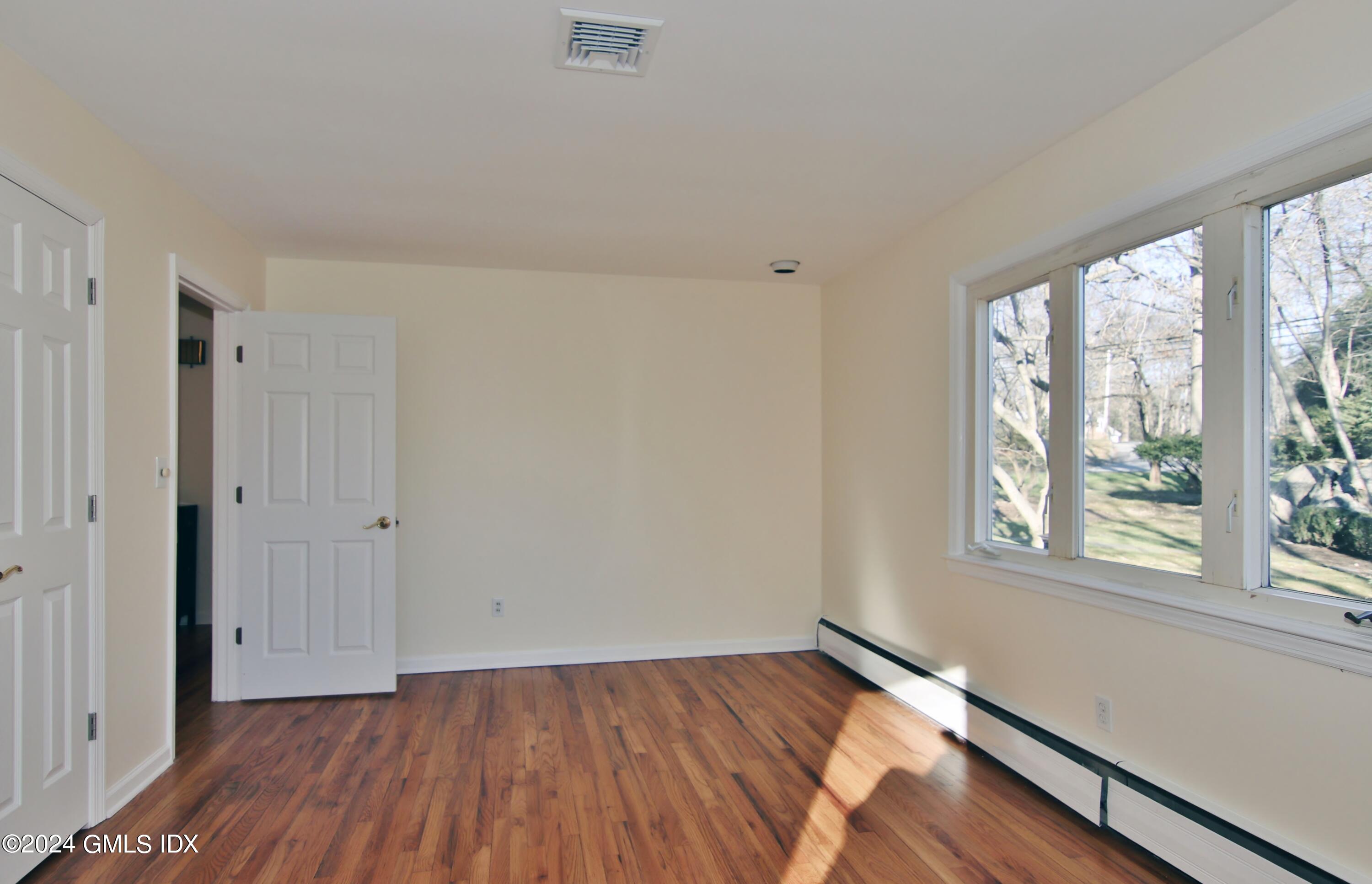 191 Sawmill Road Stamford, CT 06903 - Photo 23 of 40 a view of an empty room with wooden floor and a window