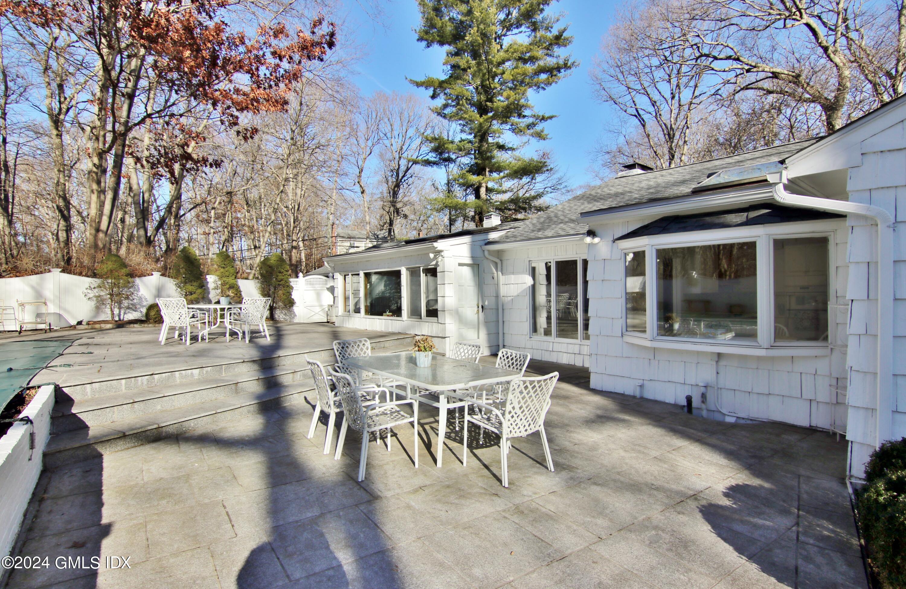 191 Sawmill Road Stamford, CT 06903 - Photo 3 of 40 a view of a patio with table and chairs and floor to ceiling window