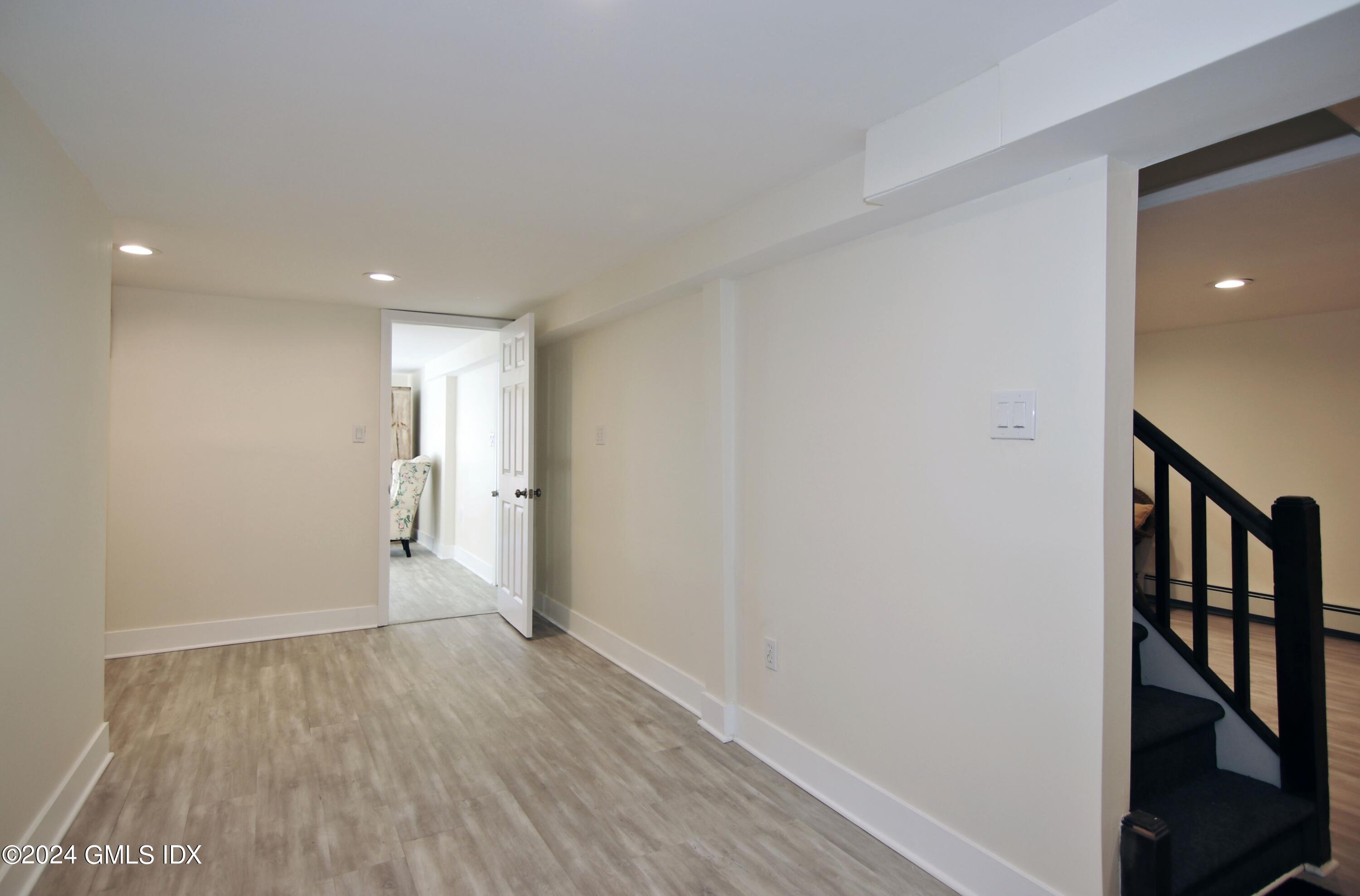 191 Sawmill Road Stamford, CT 06903 - Photo 31 of 40 a view of an empty room with wooden floor and stairs