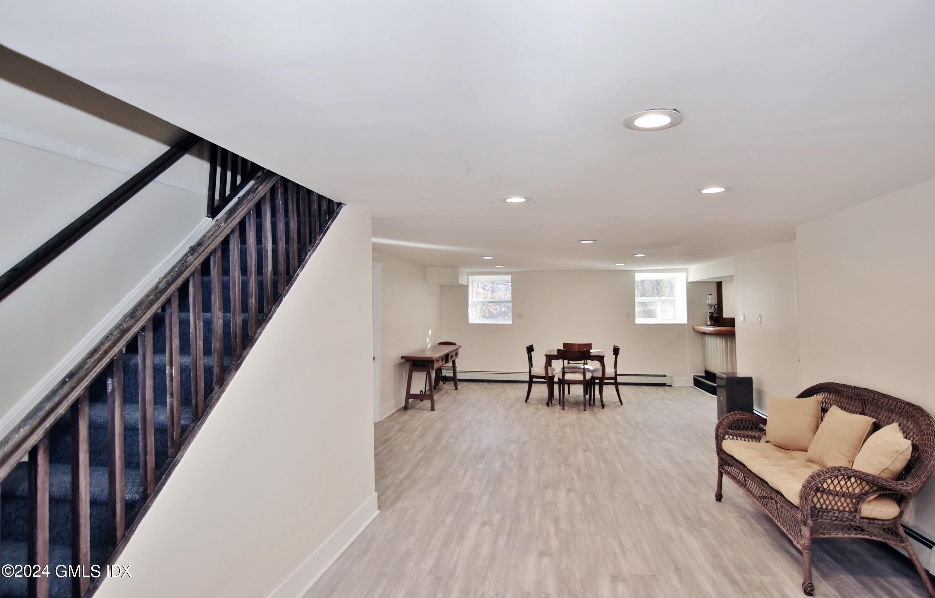 191 Sawmill Road Stamford, CT 06903 - Photo 32 of 40 a living room with furniture and a dining table with wooden floor