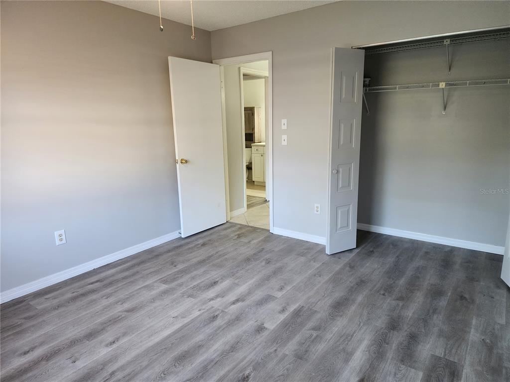 1102 Halton Court, Unit 1102 Sun City Center, FL 33573 - Photo 20 of 58 a view of an empty room with wooden floor and a window