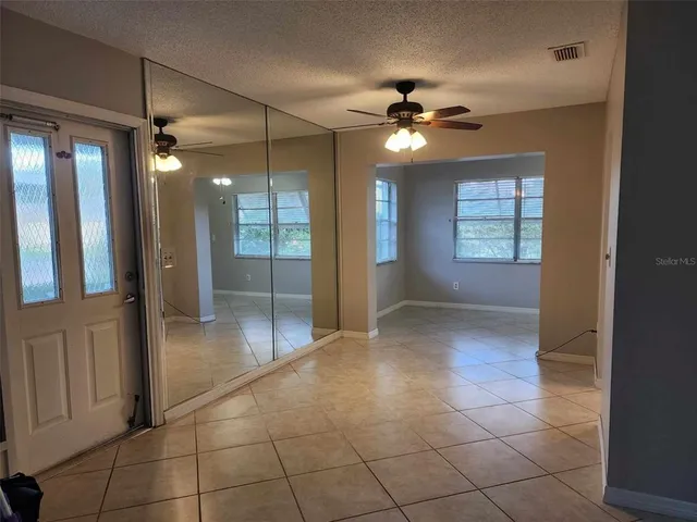 a view of an empty room with a ceiling fan