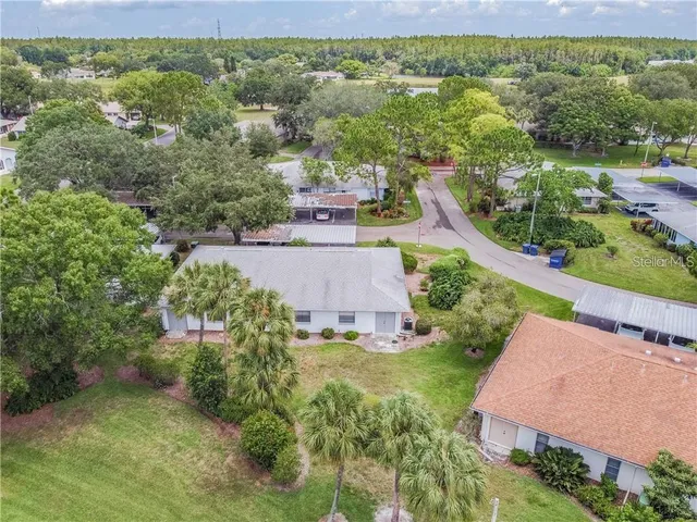 a backyard of a house with table and chairs plants