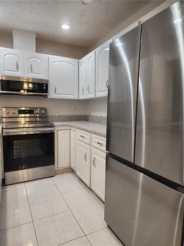 a large kitchen with stainless steel appliances granite countertop a stove sink and cabinets