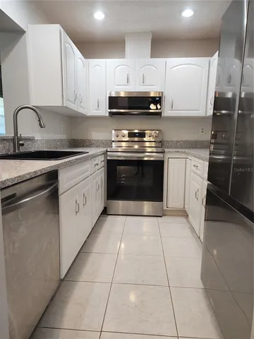 a kitchen with stainless steel appliances granite countertop a sink and a stove