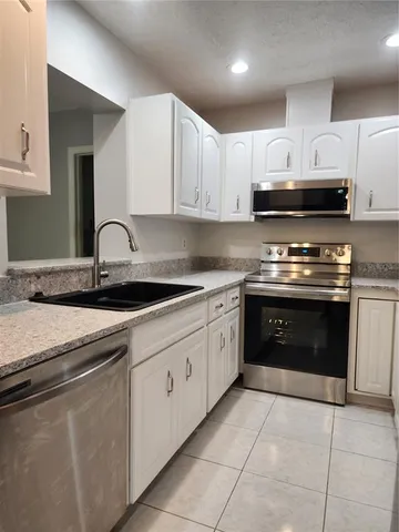 an empty room with wooden floor ceiling fan and windows