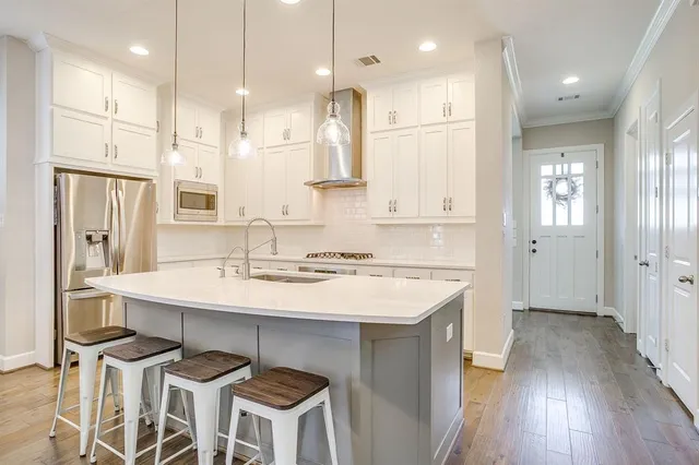 a kitchen with a sink refrigerator and wooden floor