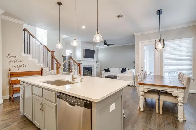 a open kitchen with stainless steel appliances kitchen island a table chairs in it and wooden floors