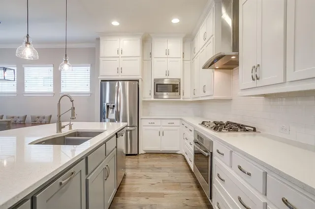 a kitchen with white cabinets sink and stainless steel appliances