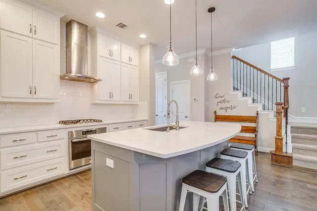 a kitchen with a sink a stove a dining table and chairs