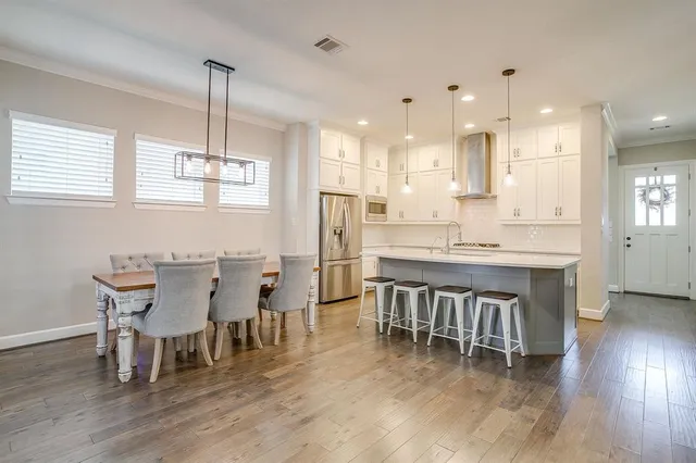 a dining room with furniture a chandelier and kitchen view