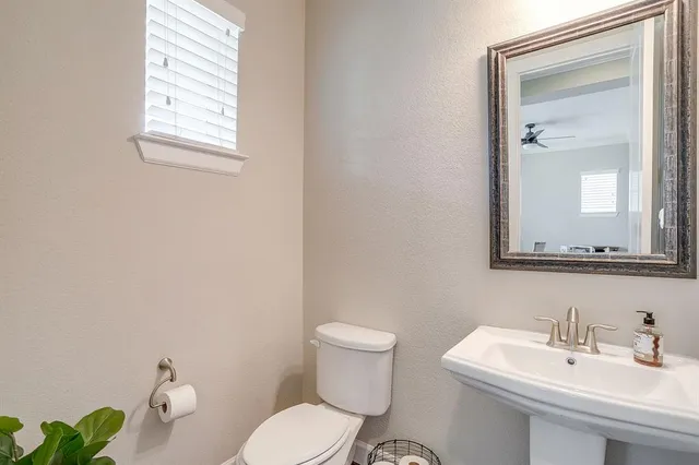 a bathroom with a toilet a sink and mirror