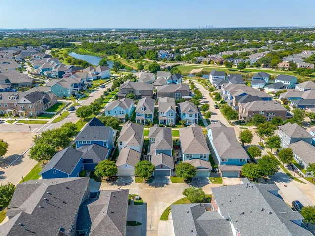 an aerial view of residential houses with outdoor space and parking