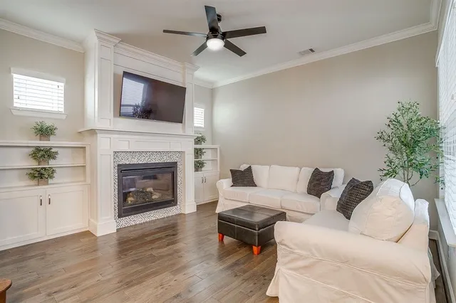 a living room with furniture a flat screen tv and a fireplace
