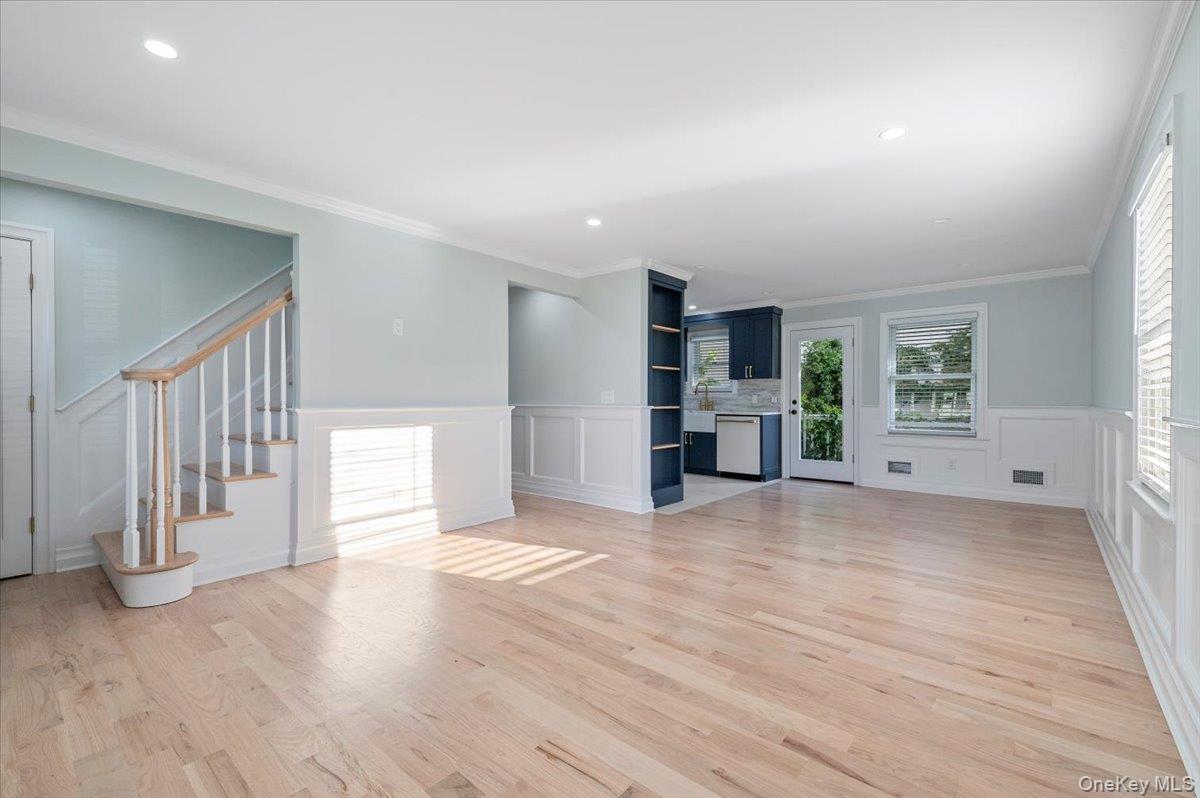 168 Martens Avenue Valley Stream, NY 11580 - Photo 4 of 26 Unfurnished living room with plenty of natural light, light wood-style flooring, recessed lighting, ornamental molding, and stairway