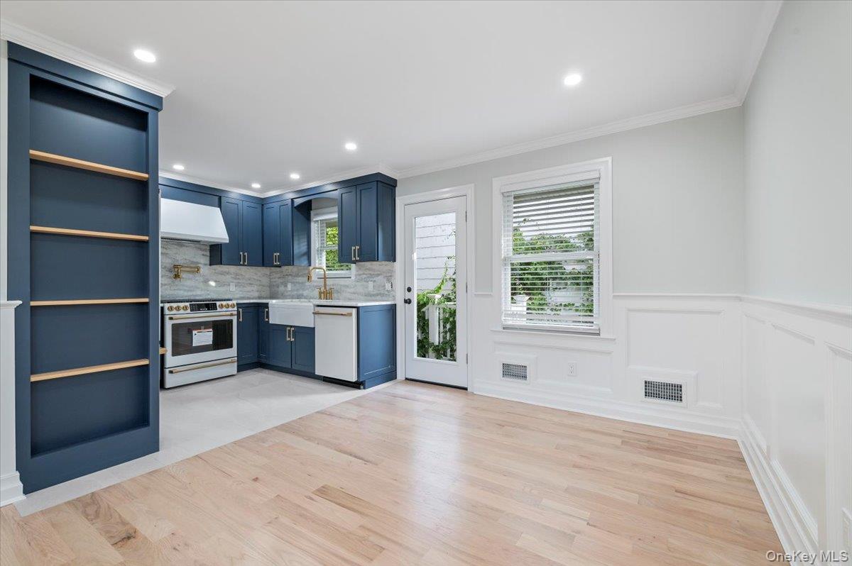 168 Martens Avenue Valley Stream, NY 11580 - Photo 7 of 26 Kitchen featuring open shelves, white appliances, light wood-type flooring, ornamental molding, and tasteful backsplash