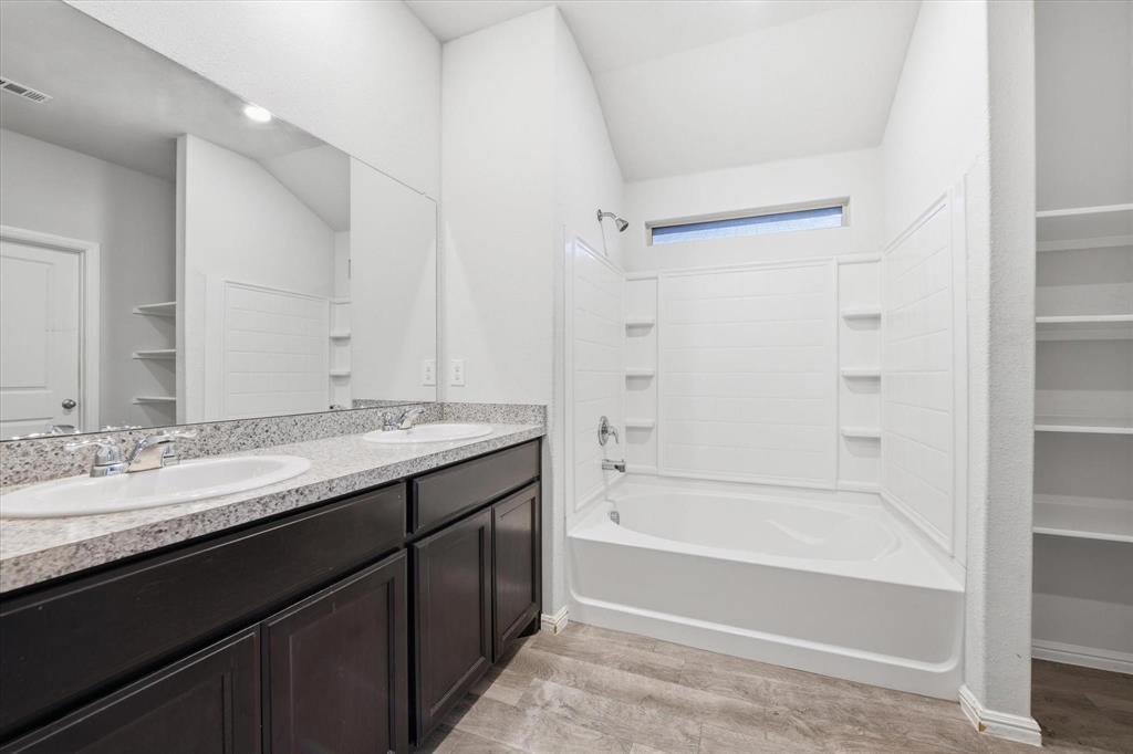 9308 Desertrock Road Fort Worth, TX 76131 - Photo 15 of 29 a bathroom with a granite countertop sink mirror bathtub and shower