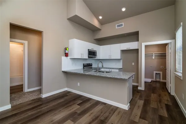 a kitchen with stainless steel appliances granite countertop a sink stove top oven and refrigerator