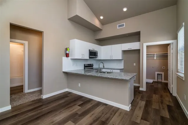 a kitchen with stainless steel appliances granite countertop a sink stove top oven and refrigerator