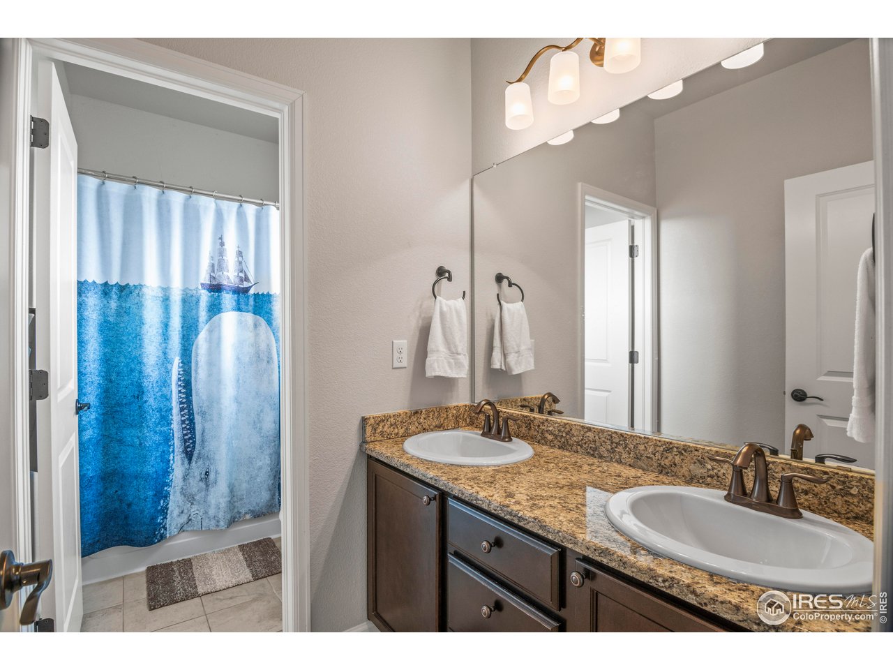 9570 Kendrick Way Arvada, CO 80007 - Photo 25 of 43 a bathroom with a granite countertop sink a mirror and shower