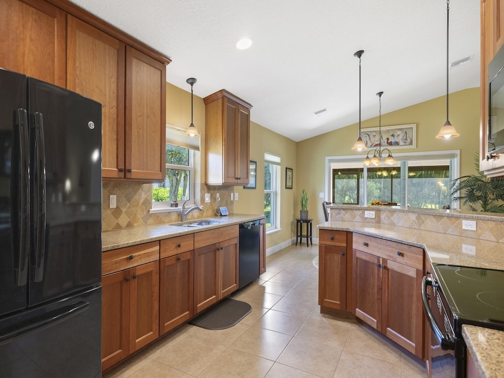 605 Monarch Way Sebastian, FL 32958 - Photo 11 of 36 a kitchen with stainless steel appliances granite countertop a sink and a refrigerator