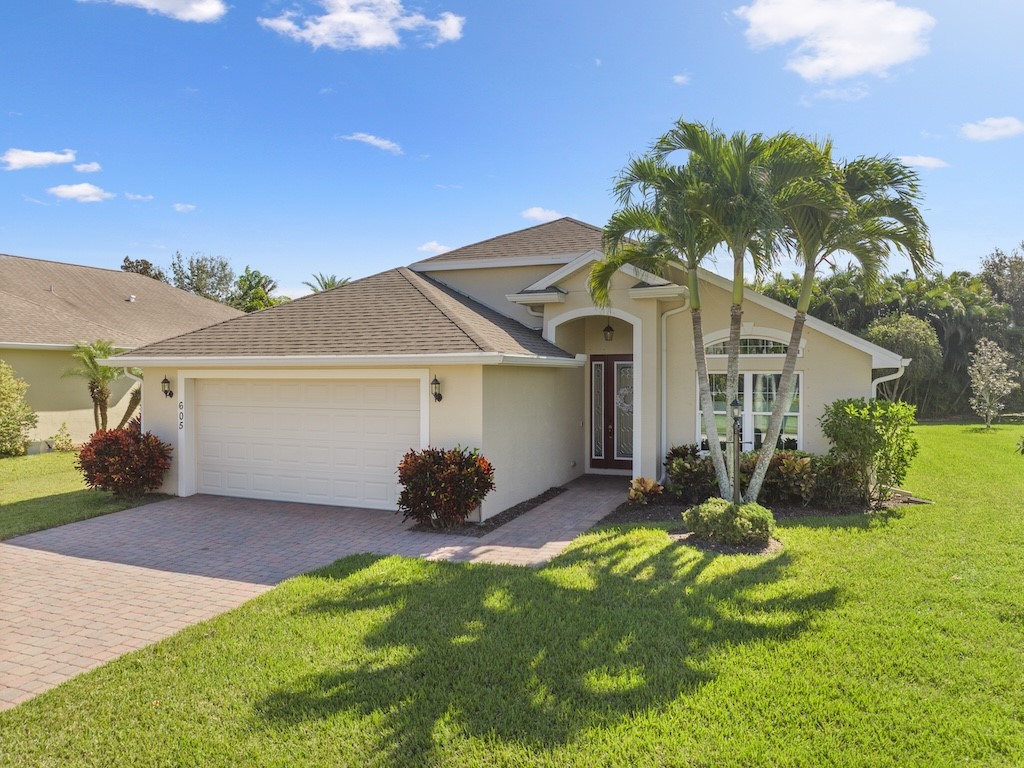 605 Monarch Way Sebastian, FL 32958 - Photo 29 of 36 a front view of a house with a yard and garage