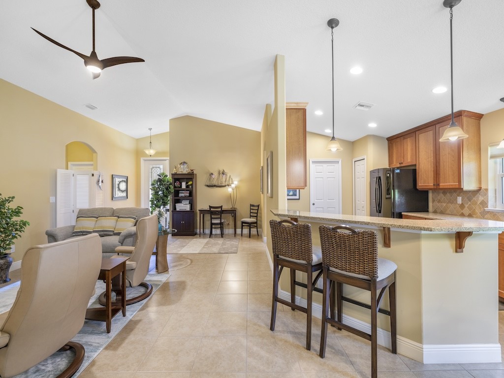 605 Monarch Way Sebastian, FL 32958 - Photo 8 of 36 a kitchen with stainless steel appliances kitchen island granite countertop a table chairs and a view of living room