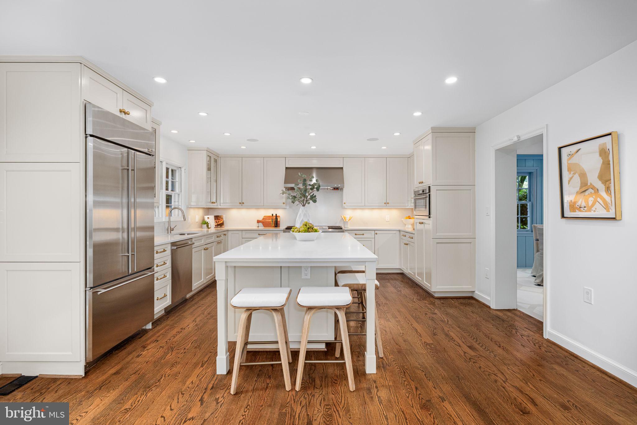 4822 Upton Street Northwest Washington, DC 20016 - Photo 9 of 48 a kitchen with stainless steel appliances a refrigerator a sink dishwasher with a dining table and chairs with wooden floor