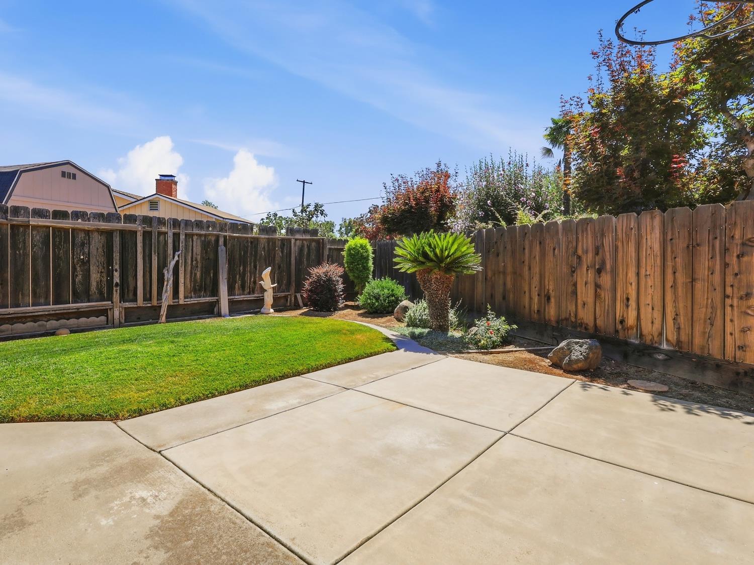 900 Multnomah Drive Modesto, CA 95350 - Photo 24 of 34 Expansive concrete patio area with a manicured lawn