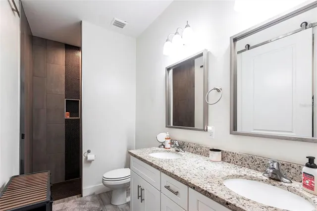 a bathroom with a granite countertop sink toilet and shower
