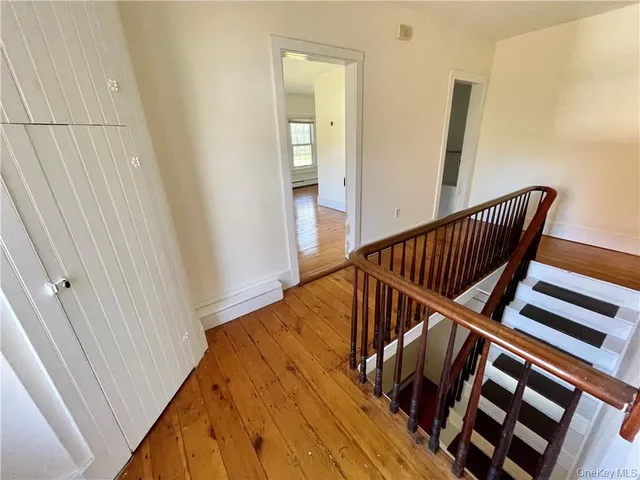 a view of staircase with railing and a window