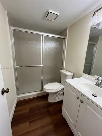 a bathroom with a sink a toilet a mirror and shower