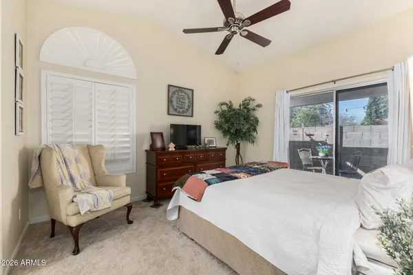 a bedroom with a bed and a lamp on a dresser