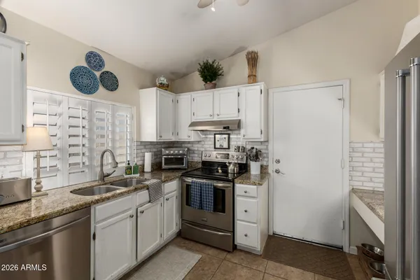 a kitchen with cabinets appliances a sink and a counter top space