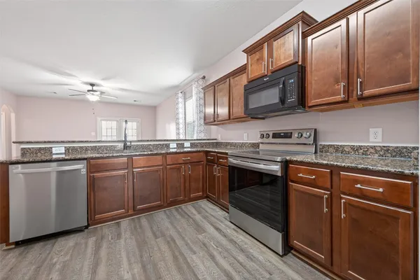a kitchen with stainless steel appliances granite countertop a sink and stove top oven