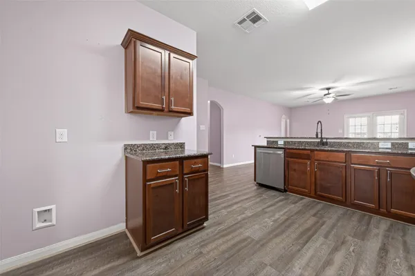 a kitchen with stainless steel appliances granite countertop a stove cabinets and wooden floor
