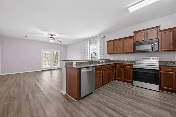 a kitchen with stainless steel appliances granite countertop a stove cabinets and wooden floor