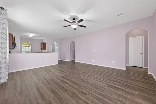 a view of an empty room with window and wooden floor