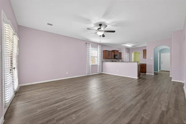 a view of an empty room with window and wooden floor