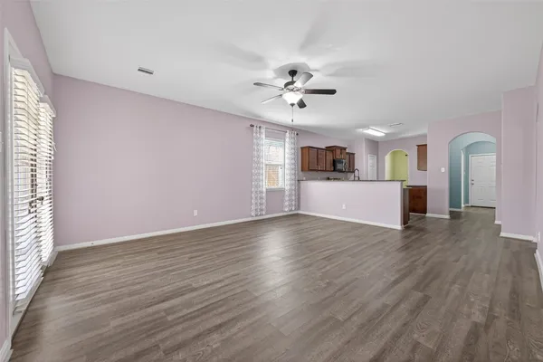 a view of an empty room with window and wooden floor