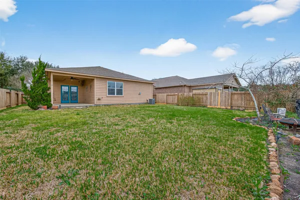 a view of a house with a big yard and large tree