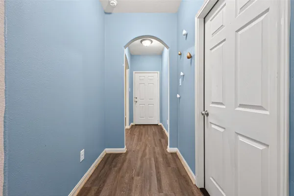 a view of a hallway with wooden floor and staircase